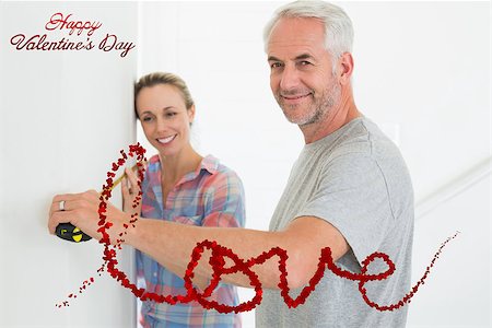 simsearch:400-04321239,k - Happy couple making some measurements together against cute valentines message Photographie de stock - Aubaine LD & Abonnement, Code: 400-07936052