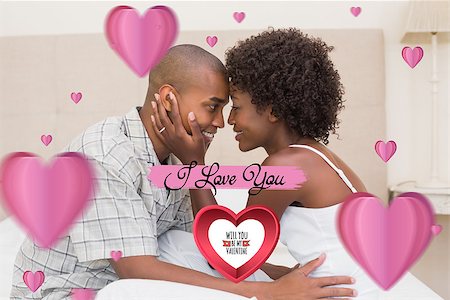 Happy couple showing affection on bed against cute valentines message Stock Photo - Budget Royalty-Free & Subscription, Code: 400-07936772
