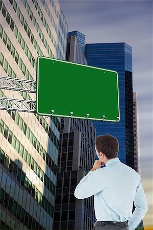 Thoughtful businessman with hand on chin against low angle view of skyscrapers Stock Photo - Budget Royalty-Free & Subscription, Code: 400-07937455