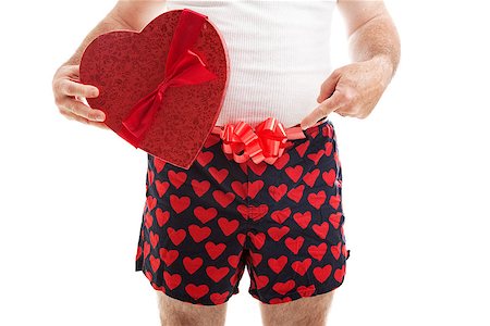 Guy in his underwear with a Valentines Day gift and a bow around his underwear, pointing toward his crotch.  Isolated on white. Stock Photo - Budget Royalty-Free & Subscription, Code: 400-07937654