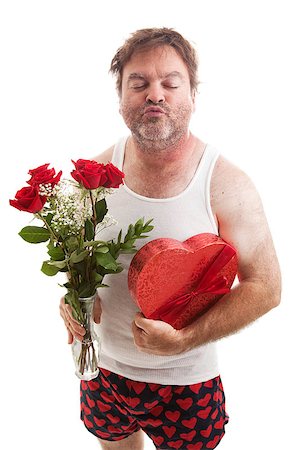 Scruffy middle aged man in his underwear with flowers and candy for Valentines Day, puckering up for a kiss.  Isolated on white. Stock Photo - Budget Royalty-Free & Subscription, Code: 400-07937651