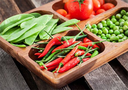 Fresh green peas, tomato and chili pepper in wooden bowl Photographie de stock - Aubaine LD & Abonnement, Code: 400-07937669