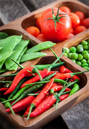 Fresh green peas, tomato and chili pepper in wooden bowl Photographie de stock - Aubaine LD & Abonnement, Code: 400-07937670