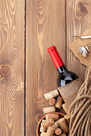 simsearch:400-07937813,k - Red wine bottle, corks and corkscrew on wooden table background with copy space Photographie de stock - Aubaine LD & Abonnement, Code: 400-07937772