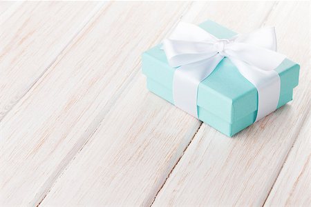 Gift box with bow over white wooden table with copy space Stock Photo - Budget Royalty-Free & Subscription, Code: 400-07937783