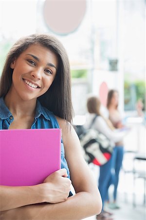 simsearch:400-07939821,k - Pretty student smiling and holding notepads at the university Photographie de stock - Aubaine LD & Abonnement, Code: 400-07938304
