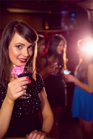 simsearch:400-07939979,k - Pretty brunette drinking a cocktail at the nightclub Fotografie stock - Microstock e Abbonamento, Codice: 400-07938508