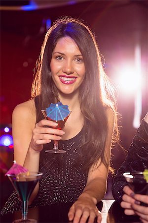 simsearch:400-07939979,k - Pretty brunette drinking a cocktail at the nightclub Fotografie stock - Microstock e Abbonamento, Codice: 400-07938540