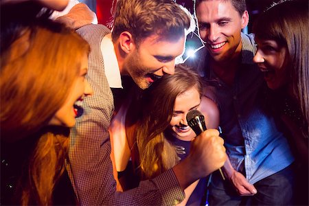 simsearch:400-07939979,k - Happy friends singing karaoke together at the nightclub Fotografie stock - Microstock e Abbonamento, Codice: 400-07938603