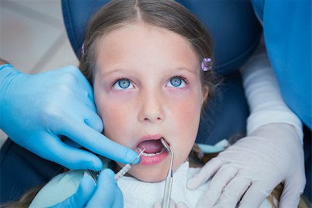 simsearch:6109-08389794,k - Dentist with assistant examining girls teeth in the dentists chair Stockbilder - Microstock & Abonnement, Bildnummer: 400-07938764