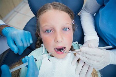 simsearch:6109-08389794,k - Dentist with assistant examining girls teeth in the dentists chair Stockbilder - Microstock & Abonnement, Bildnummer: 400-07938762