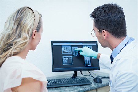 simsearch:6109-08389794,k - Side view of male dentist showing woman her mouth x-ray on computer Stockbilder - Microstock & Abonnement, Bildnummer: 400-07938777
