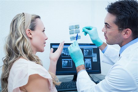 simsearch:6109-08389794,k - Side view of male dentist showing woman her mouth x-ray Stockbilder - Microstock & Abonnement, Bildnummer: 400-07938784