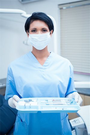 dentistry tray - Portrait of female dentist in blue scrubs holding tray of tools Stock Photo - Budget Royalty-Free & Subscription, Code: 400-07938909