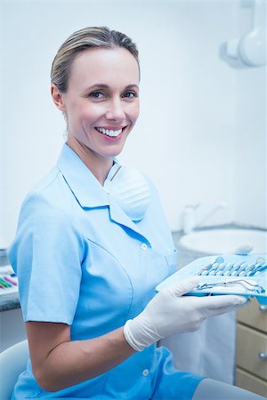simsearch:400-07941454,k - Portrait of female dentist in blue scrubs holding tray of tools Stockbilder - Microstock & Abonnement, Bildnummer: 400-07938919