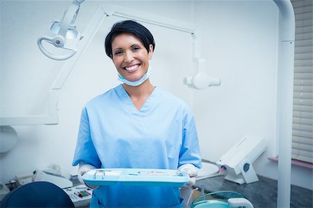 simsearch:400-07941454,k - Portrait of female dentist in blue scrubs holding tray of tools Stockbilder - Microstock & Abonnement, Bildnummer: 400-07938913