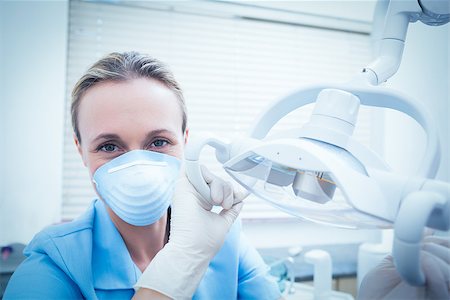 simsearch:400-07938964,k - Portrait of young female dentist adjusting light Stockbilder - Microstock & Abonnement, Bildnummer: 400-07938924