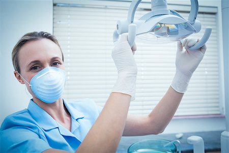 simsearch:400-07938964,k - Portrait of young female dentist adjusting light Stockbilder - Microstock & Abonnement, Bildnummer: 400-07938923