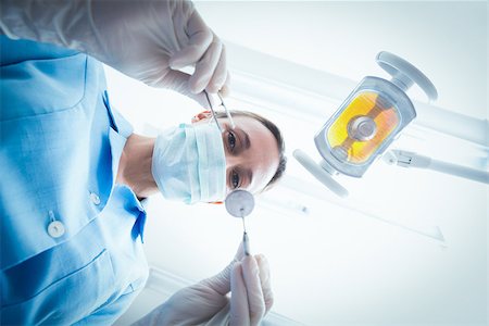 simsearch:400-07940798,k - Low angle portrait of female dentist in surgical mask holding dental tools Stock Photo - Budget Royalty-Free & Subscription, Code: 400-07938956