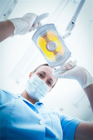 simsearch:400-07938947,k - Low angle portrait of female dentist adjusting light Photographie de stock - Aubaine LD & Abonnement, Code: 400-07938958