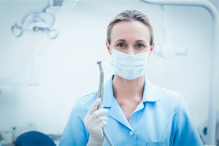 simsearch:400-07938947,k - Portrait of female dentist in surgical mask holding dental tool Photographie de stock - Aubaine LD & Abonnement, Code: 400-07938964