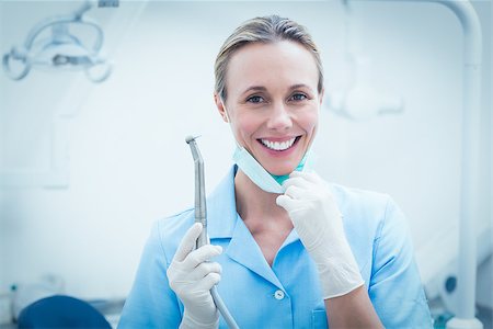 simsearch:400-07938824,k - Portrait of smiling young female dentist holding dental tool Foto de stock - Super Valor sin royalties y Suscripción, Código: 400-07938965