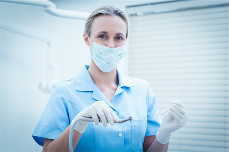 simsearch:400-07941465,k - Portrait of female dentist in surgical mask holding dental tools Stock Photo - Budget Royalty-Free & Subscription, Code: 400-07938969