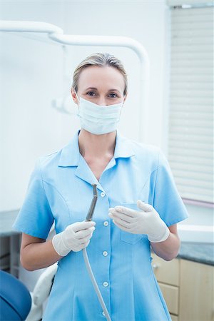 simsearch:400-07938947,k - Portrait of female dentist in surgical mask holding dental tool Photographie de stock - Aubaine LD & Abonnement, Code: 400-07938963