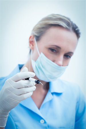 simsearch:400-07940798,k - Portrait of young female dentist in surgical mask holding injection Stock Photo - Budget Royalty-Free & Subscription, Code: 400-07938974