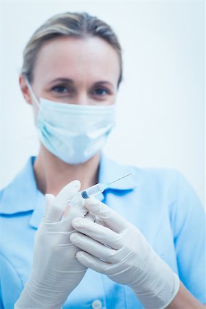 simsearch:400-07940798,k - Portrait of young female dentist in surgical mask holding injection Stock Photo - Budget Royalty-Free & Subscription, Code: 400-07938973