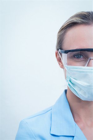 simsearch:400-07940798,k - Cropped young female dentist wearing surgical mask and safety glasses Stock Photo - Budget Royalty-Free & Subscription, Code: 400-07938984