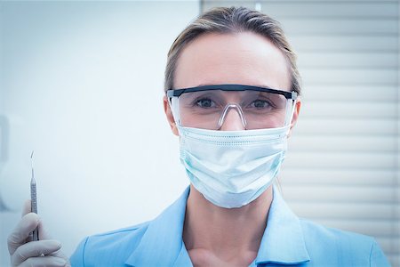 simsearch:400-07938964,k - Portrait of female dentist in surgical mask and safety glasses holding injection Stockbilder - Microstock & Abonnement, Bildnummer: 400-07938985