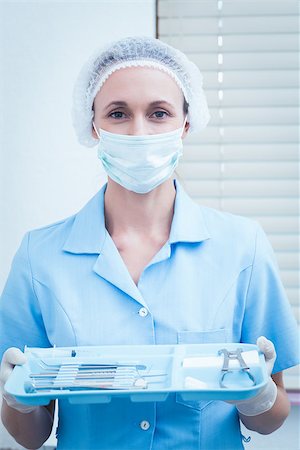 simsearch:400-07938947,k - Portrait of female dentist in surgical mask holding tray of tools Photographie de stock - Aubaine LD & Abonnement, Code: 400-07938986