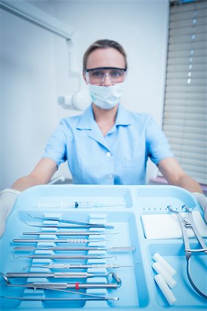 simsearch:400-07938964,k - Portrait of female dentist in surgical mask holding tray of tools Stockbilder - Microstock & Abonnement, Bildnummer: 400-07938990