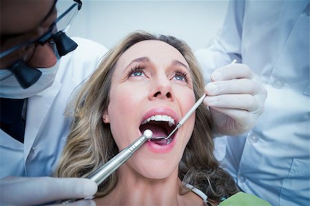 Close up of woman having her teeth examined by dentist and assistant Foto de stock - Super Valor sin royalties y Suscripción, Código: 400-07939052