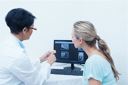simsearch:400-07938824,k - Side view of female dentist showing woman her mouth x-ray on computer Foto de stock - Super Valor sin royalties y Suscripción, Código: 400-07939116