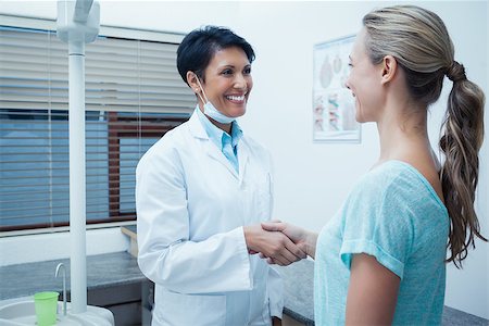 simsearch:400-07938947,k - Side view of female dentist shaking hands with woman Photographie de stock - Aubaine LD & Abonnement, Code: 400-07939111