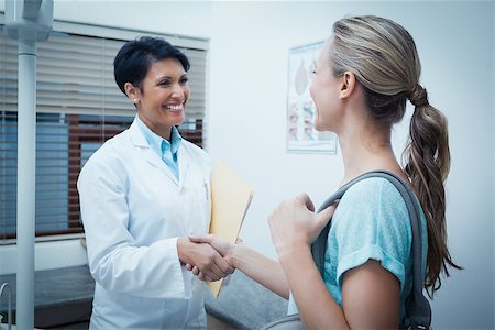 simsearch:400-07938947,k - Side view of female dentist shaking hands with woman Photographie de stock - Aubaine LD & Abonnement, Code: 400-07939113