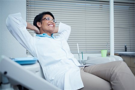 dental work - Relaxed smiling female dentist sitting on chair with hands behind head Stock Photo - Budget Royalty-Free & Subscription, Code: 400-07939141