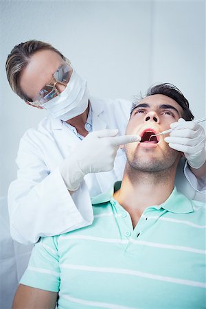 simsearch:400-07938947,k - Female dentist examining mans teeth in the dentists chair Photographie de stock - Aubaine LD & Abonnement, Code: 400-07939179