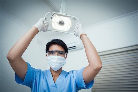 simsearch:400-07938824,k - Low angle portrait of female dentist adjusting light Foto de stock - Super Valor sin royalties y Suscripción, Código: 400-07939172