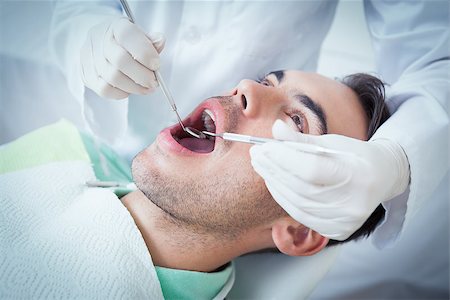 simsearch:6109-08389794,k - Close up of man having his teeth examined by dentist Stockbilder - Microstock & Abonnement, Bildnummer: 400-07939181