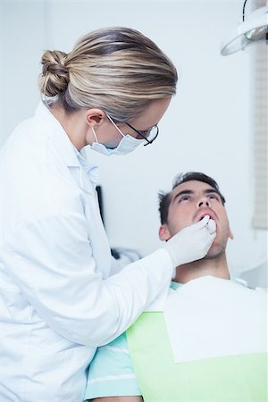 simsearch:6109-08389794,k - Female dentist examining mans teeth in the dentists chair Stockbilder - Microstock & Abonnement, Bildnummer: 400-07939192