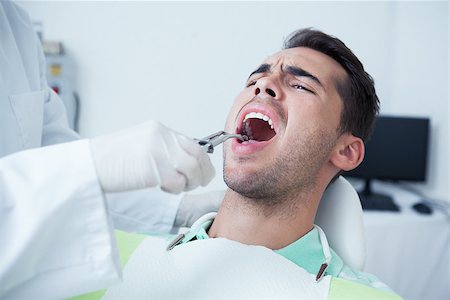 simsearch:6109-08389794,k - Close up of man having his teeth examined by dentist Stockbilder - Microstock & Abonnement, Bildnummer: 400-07939193