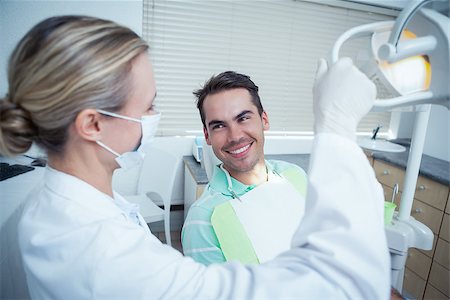 simsearch:400-07938964,k - Female dentist examining mans teeth in the dentists chair Stockbilder - Microstock & Abonnement, Bildnummer: 400-07939212