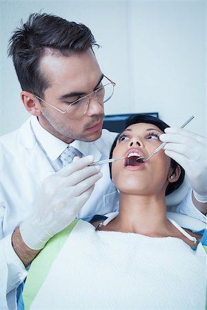 simsearch:6109-08389794,k - Male dentist examining womans teeth in the dentists chair Stockbilder - Microstock & Abonnement, Bildnummer: 400-07939247