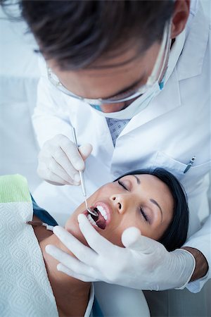 simsearch:6109-08389794,k - Male dentist examining womans teeth in the dentists chair Stockbilder - Microstock & Abonnement, Bildnummer: 400-07939255