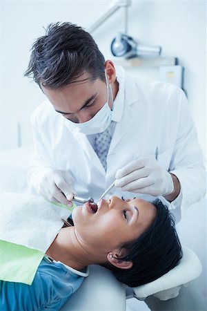 simsearch:6109-08389794,k - Male dentist examining womans teeth in the dentists chair Stockbilder - Microstock & Abonnement, Bildnummer: 400-07939256