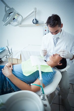 simsearch:6109-08389794,k - Male dentist examining womans teeth in the dentists chair Stockbilder - Microstock & Abonnement, Bildnummer: 400-07939253