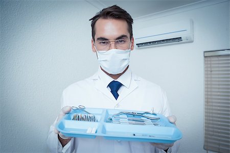 simsearch:6109-08389797,k - Portrait of male dentist in surgical mask holding tray of tools Stock Photo - Budget Royalty-Free & Subscription, Code: 400-07939278